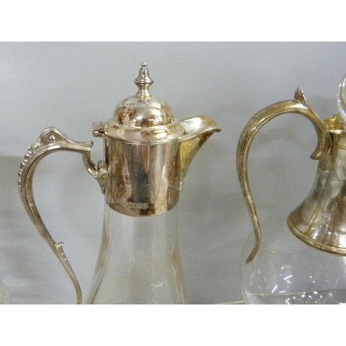 843 - Three silver topped glass claret jugs