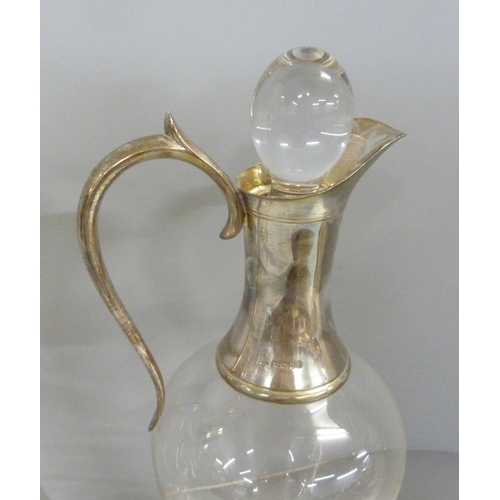 843 - Three silver topped glass claret jugs