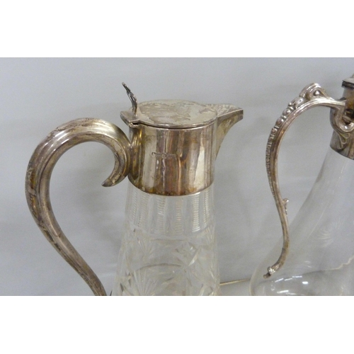 843 - Three silver topped glass claret jugs