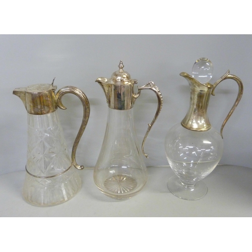 843 - Three silver topped glass claret jugs