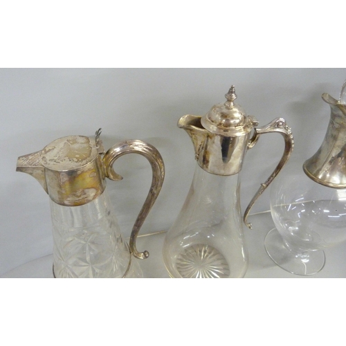 843 - Three silver topped glass claret jugs