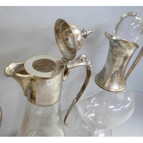 843 - Three silver topped glass claret jugs