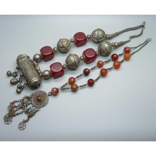 874 - Two North African tribal necklaces, one white metal and faceted beads and one with cylindrical penda... 