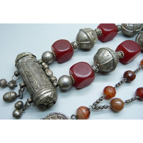 874 - Two North African tribal necklaces, one white metal and faceted beads and one with cylindrical penda... 