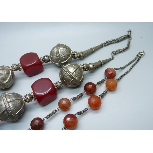 874 - Two North African tribal necklaces, one white metal and faceted beads and one with cylindrical penda... 