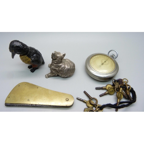 878 - A silver covered model cat, a nodding cold painted model bird, a fleam, watch keys, etc.