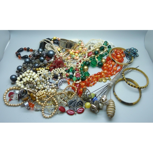 930 - A tin of costume jewellery and hat pins