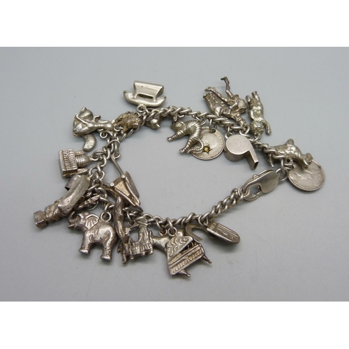 979 - A silver charm bracelet, with approximately 26 silver and white metal charms including 9 animals, 94... 