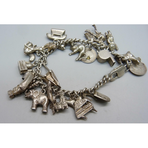 979 - A silver charm bracelet, with approximately 26 silver and white metal charms including 9 animals, 94... 