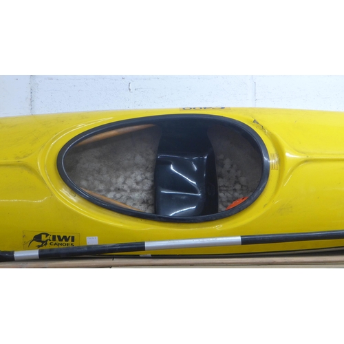 2064 - A Fiberglass Kiwi Slalom 400 canoe with paddle and a plastic safety helmet