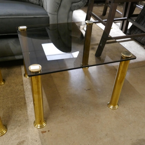 1433 - A square corner table, toughened smoked glass with solid brass legs
