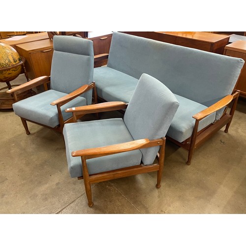 17 - A Guy Rogers teak and blue fabric upholstered three piece Manhattan lounge suite, comprising; settee... 