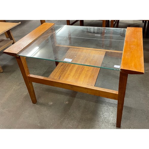 25 - A teak and glass topped coffee table