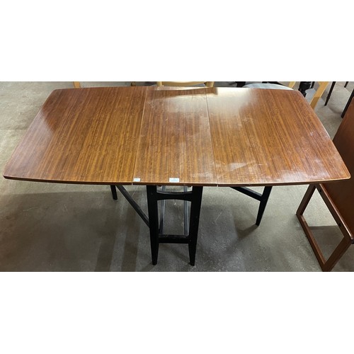 36 - A tola wood and black drop leaf table and two chairs