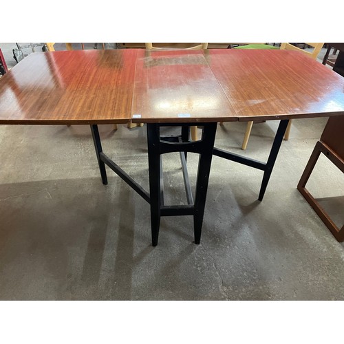 36 - A tola wood and black drop leaf table and two chairs