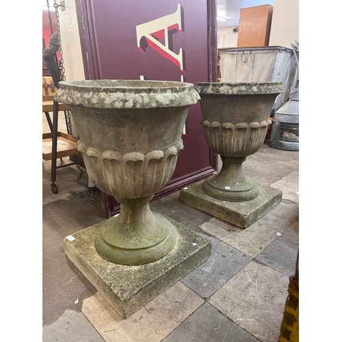 247 - A pair of reconstituted stone garden urns