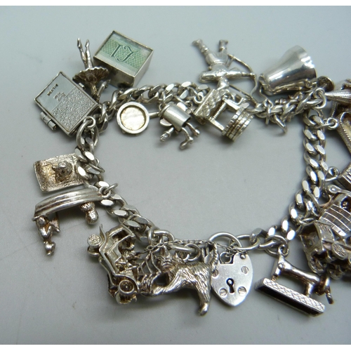 1009 - A silver charm bracelet, 64.5g