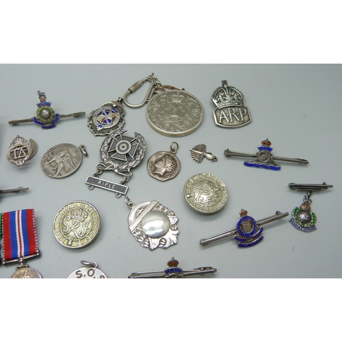 1070 - A collection of enamelled regimental brooches/badges, a silver ARP badge, fobs, medallions, a silver... 