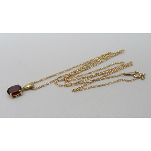 1091 - A 9ct yellow gold pendant with ruby coloured stone and chain, 1.6g total