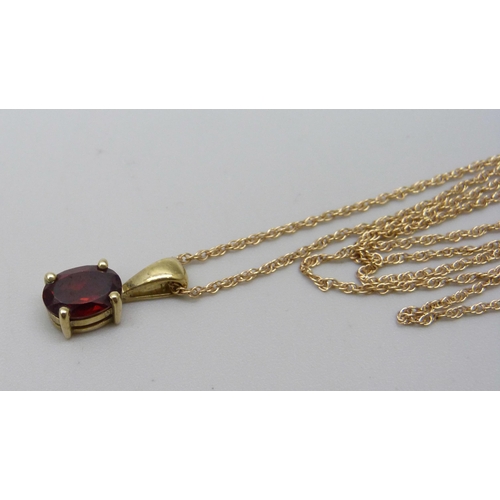 1091 - A 9ct yellow gold pendant with ruby coloured stone and chain, 1.6g total