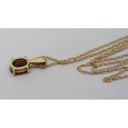 1091 - A 9ct yellow gold pendant with ruby coloured stone and chain, 1.6g total