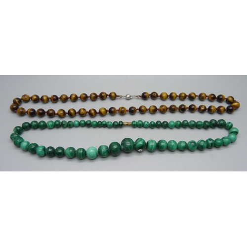 1098 - A string of tiger's eye beads on a silver clasp and a string of malachite beads