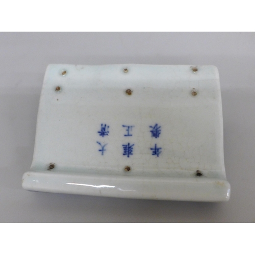 628 - A Chinese porcelain blue and white brush or pen rest, six character Kangxi mark