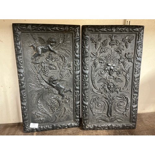 313 - A pair of black faux bronze cherub wall plaques