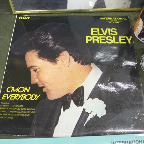 797 - A collection of Elvis Presley items including two prints, framed, two mugs, four records and a book