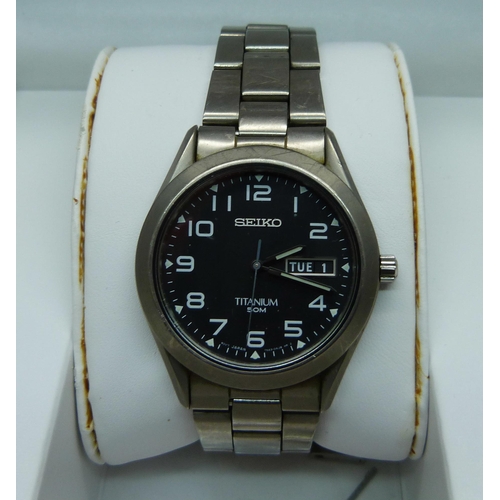 845 - A Seiko Titanium day date wristwatch with spare links