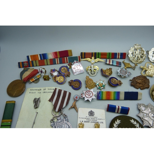 940 - A collection of military badges, uniform badges, other badges, etc.