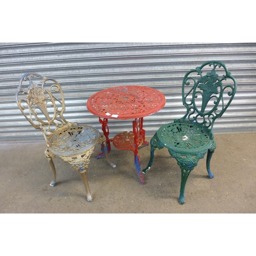 2131 - A three piece cast metal garden set with two chairs and a circular table