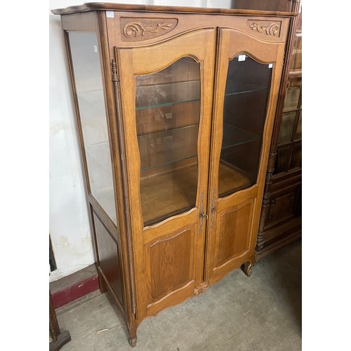 103 - A French carved oak two door display cabinet