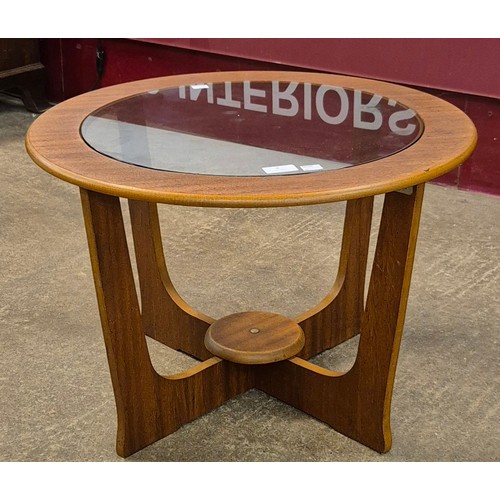 8 - A teak and glass topped circular coffee table