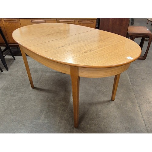 74 - A teak oval extending dining table