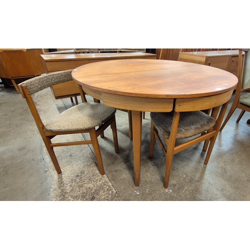 77 - A teak circular extending dining table and four chairs