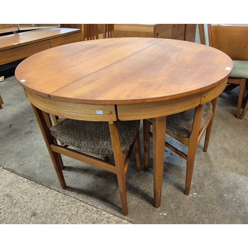 77 - A teak circular extending dining table and four chairs