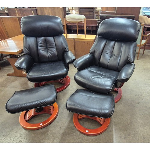 79 - A pair of beech and black leather revolving lounge chairs and ottomans