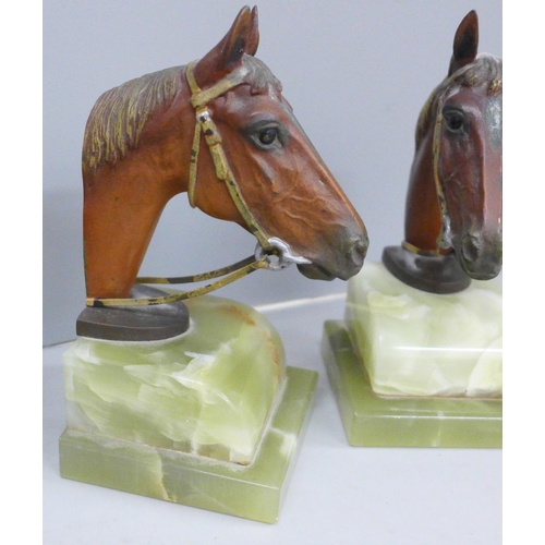 624 - A pair of cold painted bronze horses head bookends on an onyx plinth, an inkstand in the form of boo... 