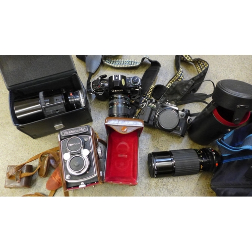 726 - A collection of camera equipment - Yashica-mat 120 twin lens reflex, Canon A1 35mm camera and case, ... 