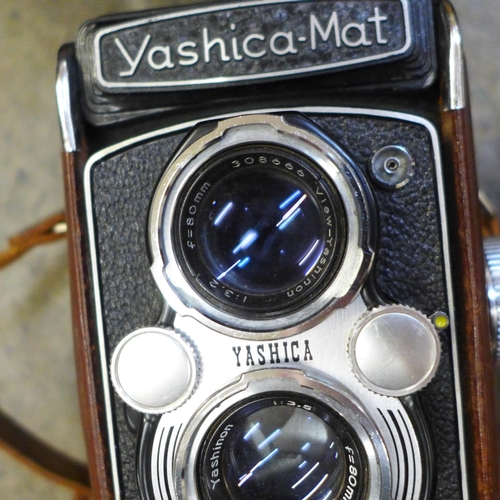 726 - A collection of camera equipment - Yashica-mat 120 twin lens reflex, Canon A1 35mm camera and case, ... 