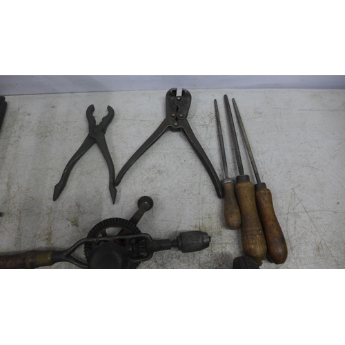 2022 - A large assortment of vintage tools including hand drills, mallets, a saw, brace drill, files, spiri... 