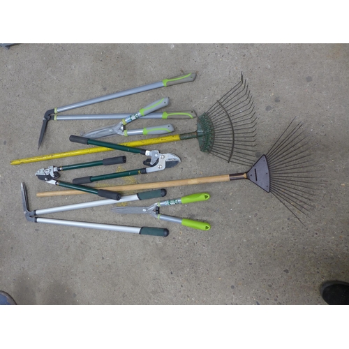 2255 - A large quantity of assorted garden tools including rakes, edging shears, loppers, branch cutters, h... 