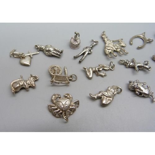 1053 - Fifteen silver and white metal charms, 31g