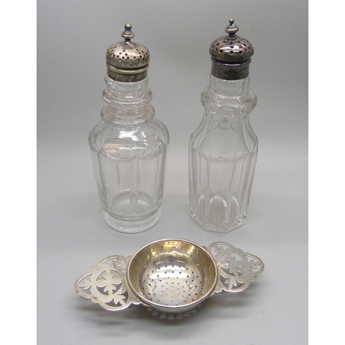 880 - A silver strainer and two silver topped peppers/condiments, silver 46g