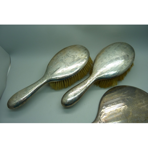 949 - Two silver backed brushes and a hand mirror