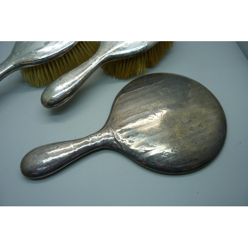 949 - Two silver backed brushes and a hand mirror