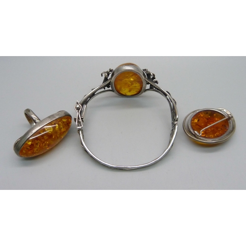 968A - A silver bangle, a silver ring and a silver brooch, set with amber, ring size O