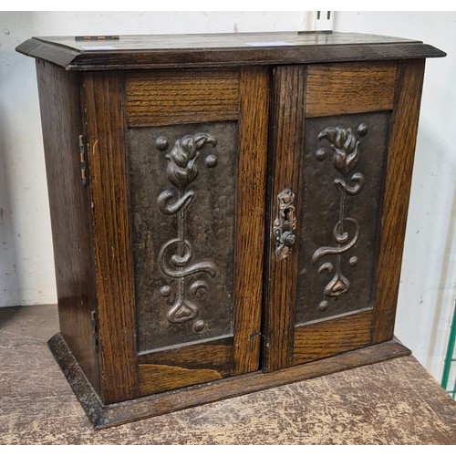 360 - An Art Nouveau carved oak and copper smokers cabinet