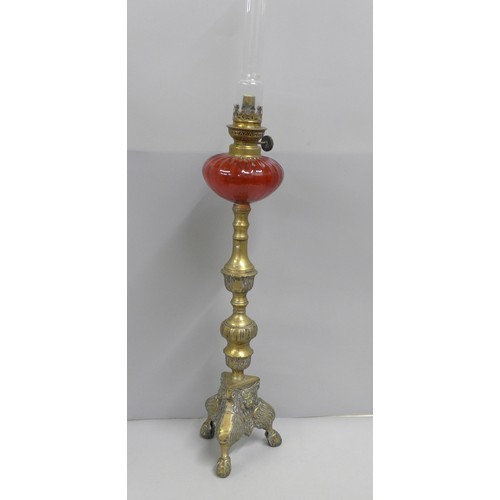 792 - A brass oil lamp with cranberry glass reservoir